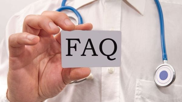 Doctor holding an FAQ card, symbolizing the provision of information on frequently asked questions regarding sarcoma cancer treatment costs.