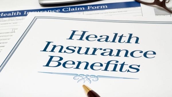 Close-up of a Health Insurance Benefits document with a pen, indicating the critical role of health insurance in managing Sarcoma cancer treatment expenses.